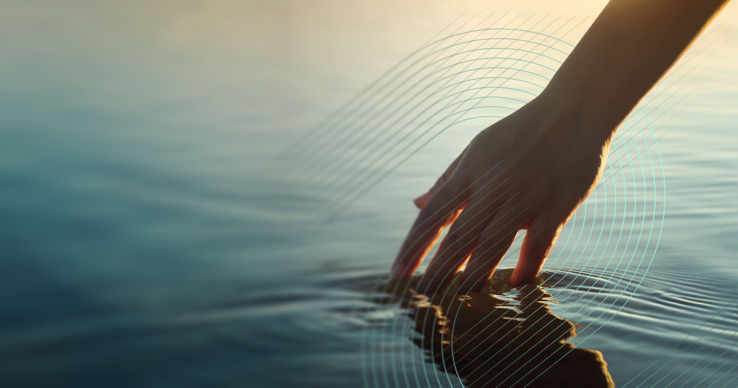 Nahaufnahme einer Hand, die mit den Finger durch klares Wasser streift